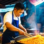 태국의 특수 요리법 - **Prompt: "Dynamic Thai Street Food Wok Master"**
A highly skilled Thai street food vendor, gend...